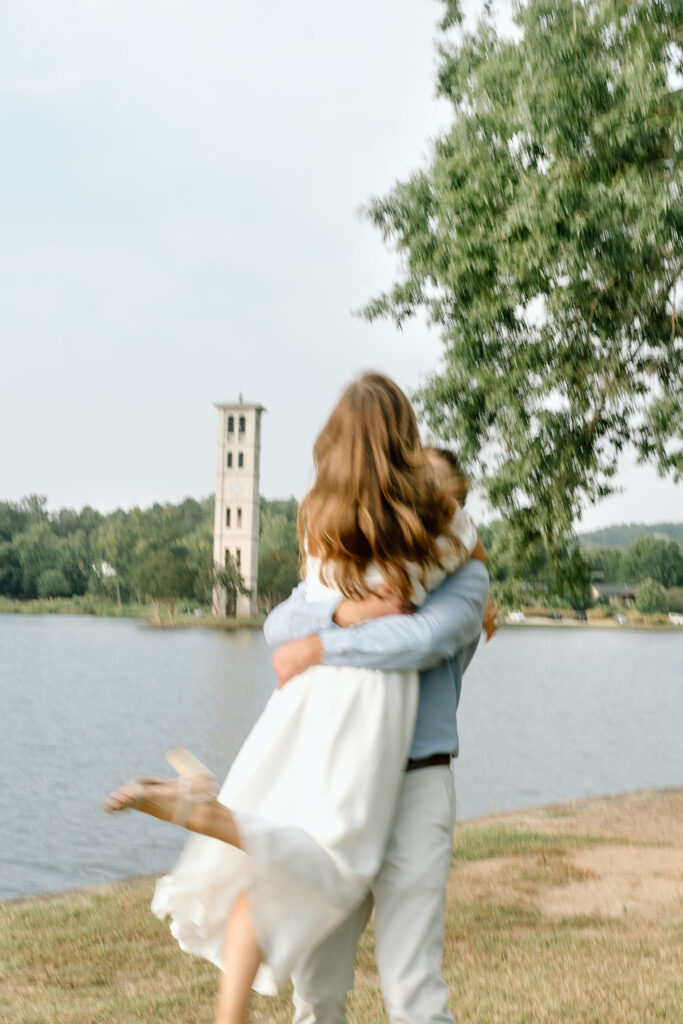 Couple posing by the Furman bell tower at Furman University outside Greenville, South Carolina