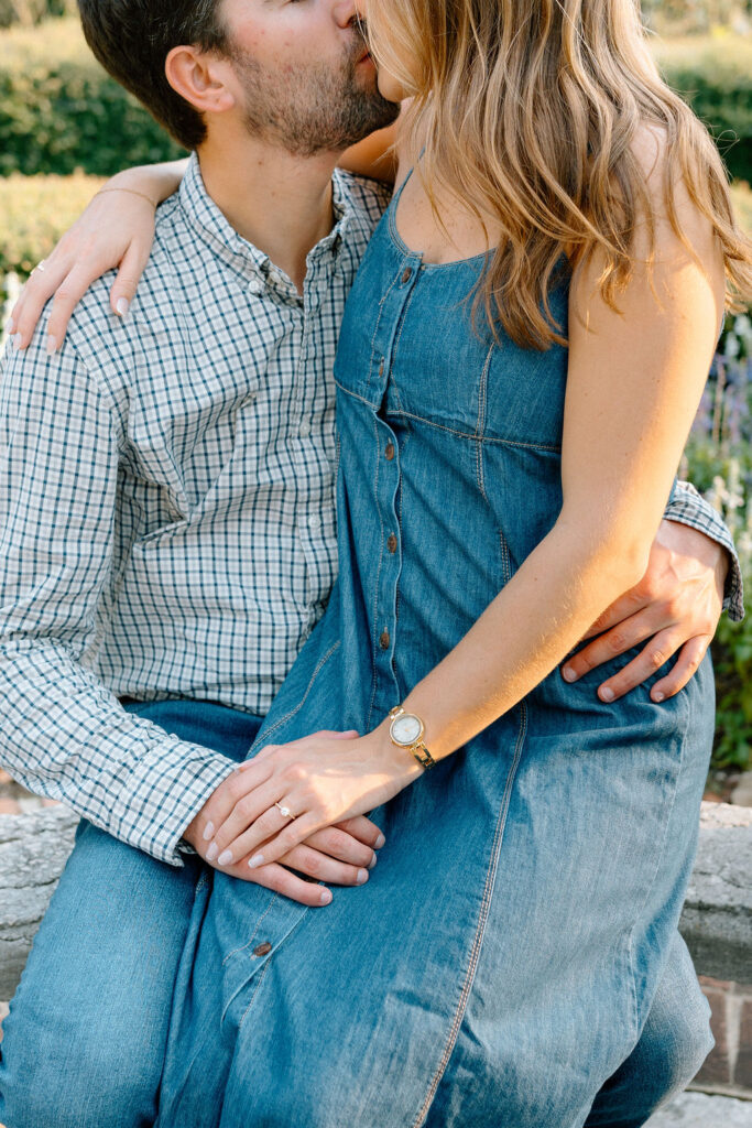 Couple embracing near the rose gardens at Furman University during engagement session
