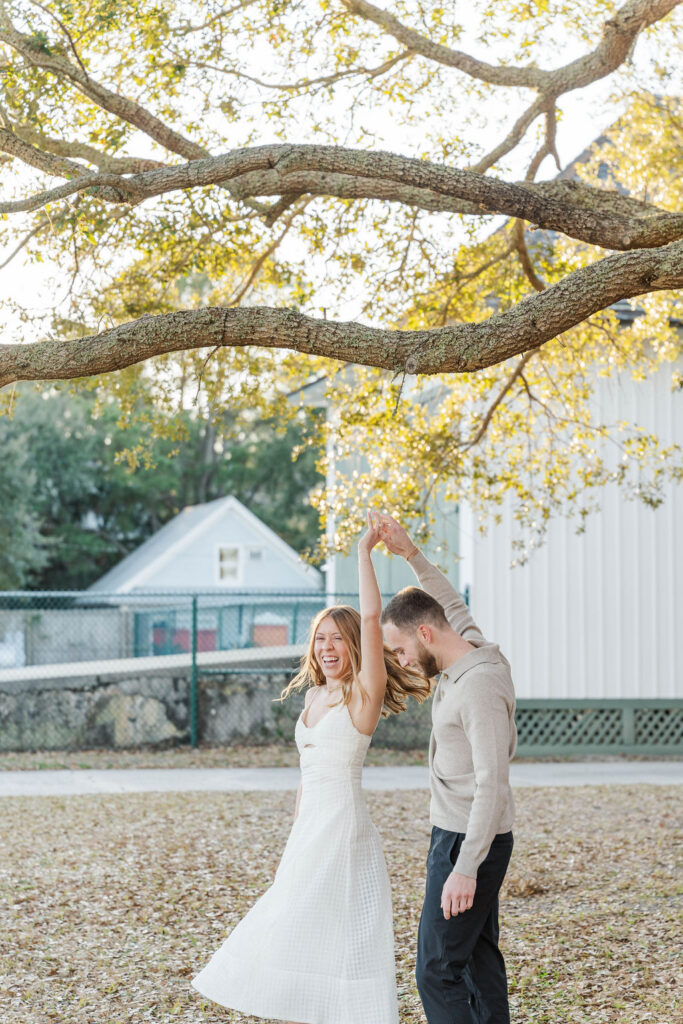 Caroline twirling under a live oak tree during her Charleston engagement photos with Jamie
