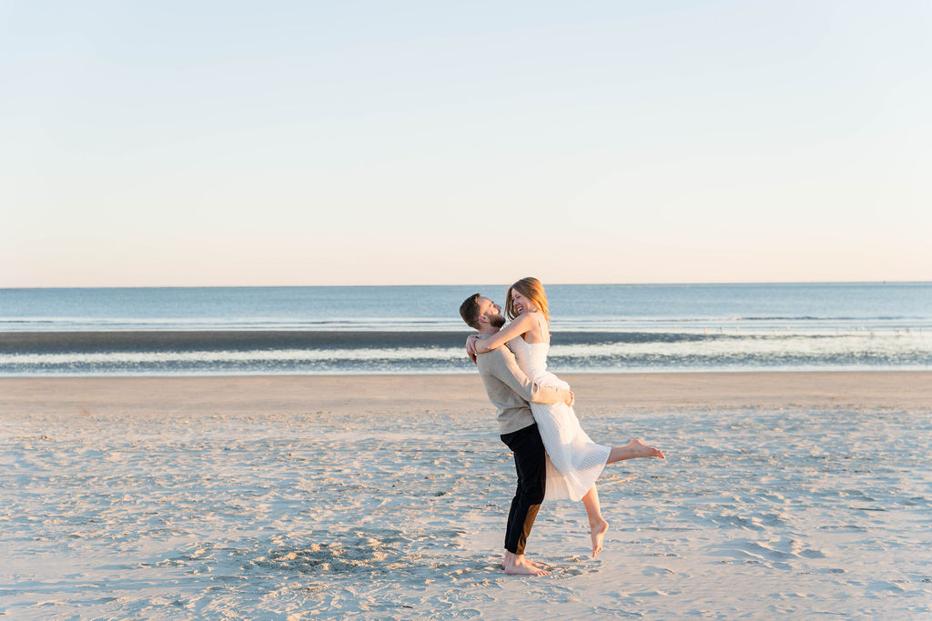 Couple embracing on the beach during golden hour engagement photos in Charleston
