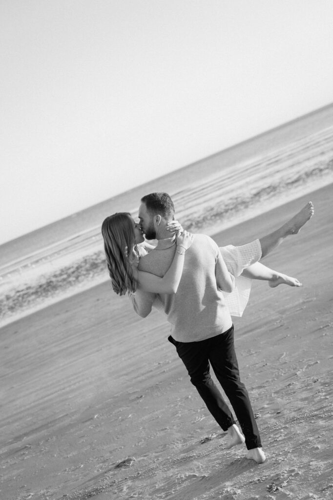 Relaxed Charleston coastal engagement photo of a couple walking together along the shoreline
