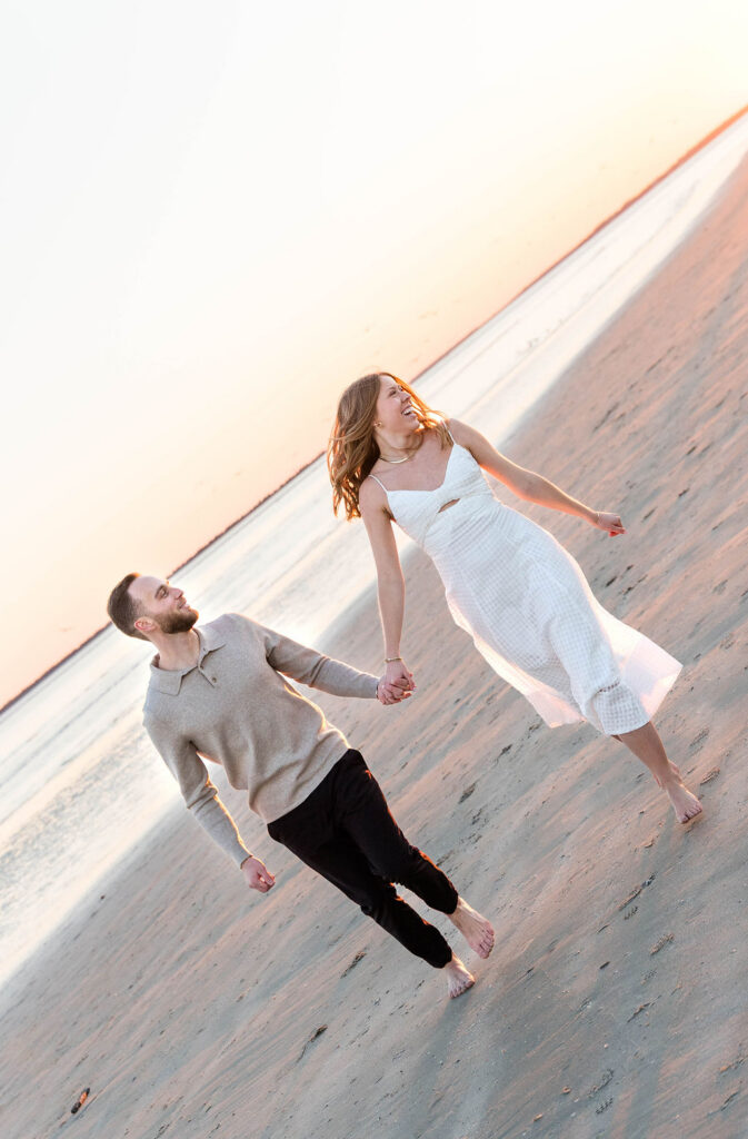Caroline and Jamie running hand in hand along the beach at Sullivan’s Island during golden hour
