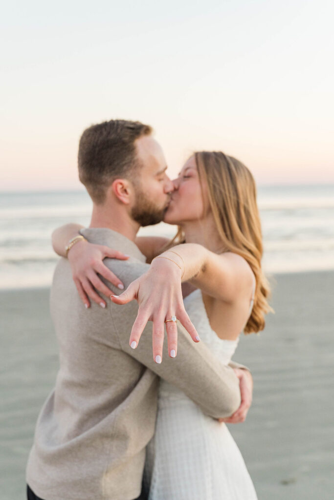 Windy beach portrait of Caroline and Jamie during their Sullivan’s Island engagement photos
