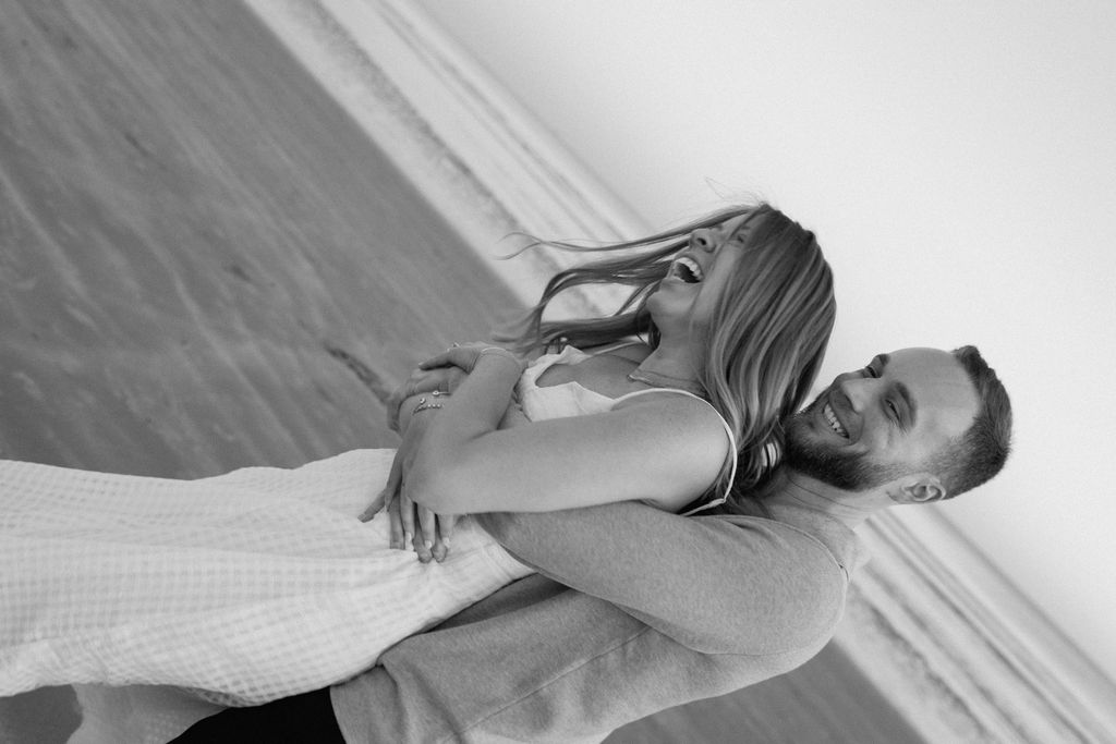 Playful portrait of Caroline and Jamie laughing during their Sullivan’s Island engagement session
